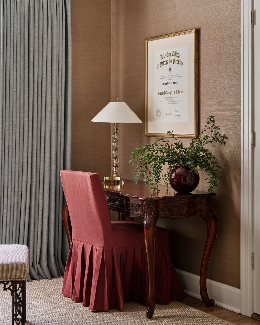 A writing desk beneath Dr. Muratides’ framed medical diploma