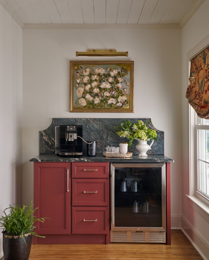 The coffee bar, with oxblood cabinetry and a floral painting