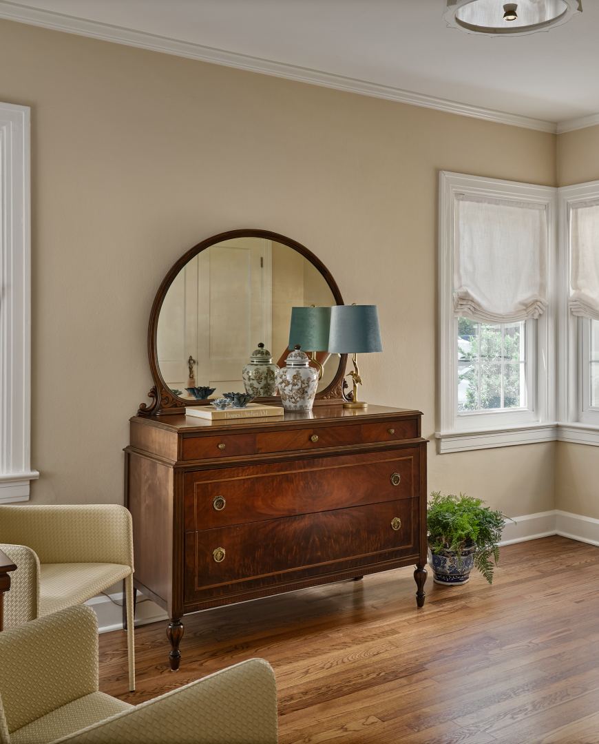 An exam room with an antique dresser and a bay window