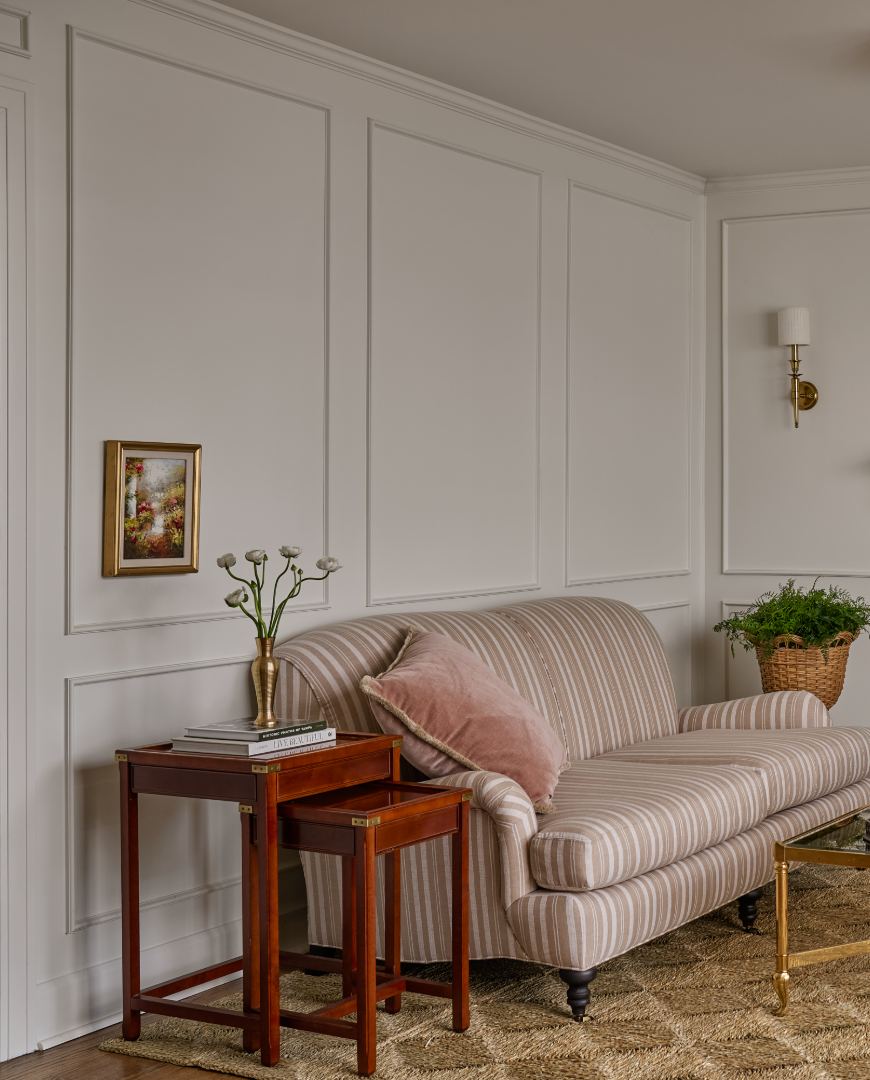 The sitting room, with a striped sofa and white panelled walls