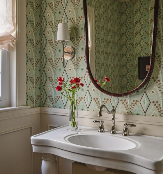 The powder room, with green patterned wallpaper and fresh flowers